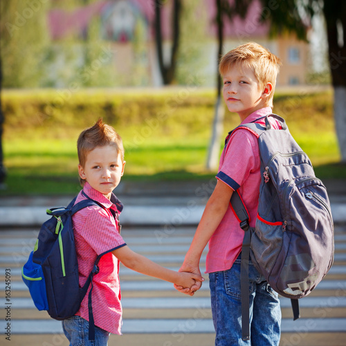 Portrait two adorable boys with backpack near pedestrian crossin.