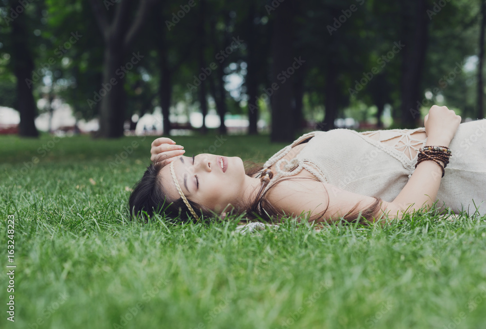 Beautiful young girl lying on grass in summer park Beautiful young girl lying on grass in summer park