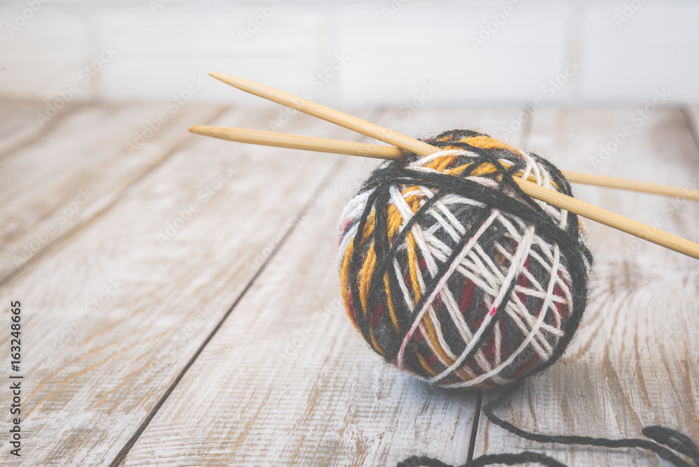 Retro photo of modern color ball of wool with knitting bamboo needles. Toned. Retro photo of modern color ball of wool with knitting bamboo needles. Toned.