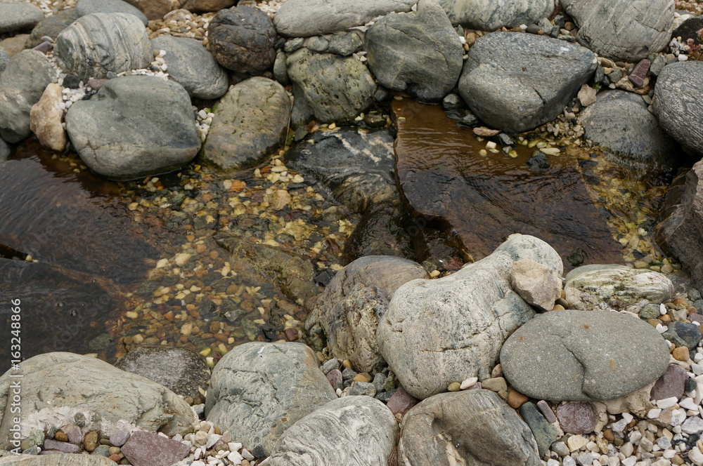 A small stone waterfall with several rapids and clear transparent spring water A small stone waterfall with several rapids and clear transparent spring water