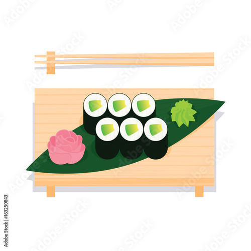 Maki sushi with avocado served on wooden board.