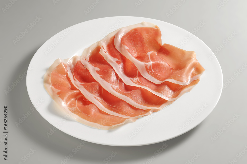 Round dish with portion of raw ham