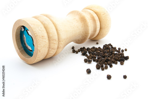 pepper mill of wood with peppercorns