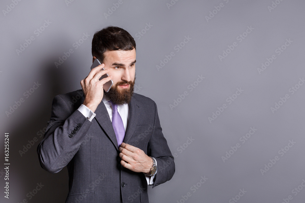 Concentrated bearded businessman talking on phone Concentrated bearded businessman talking on phone