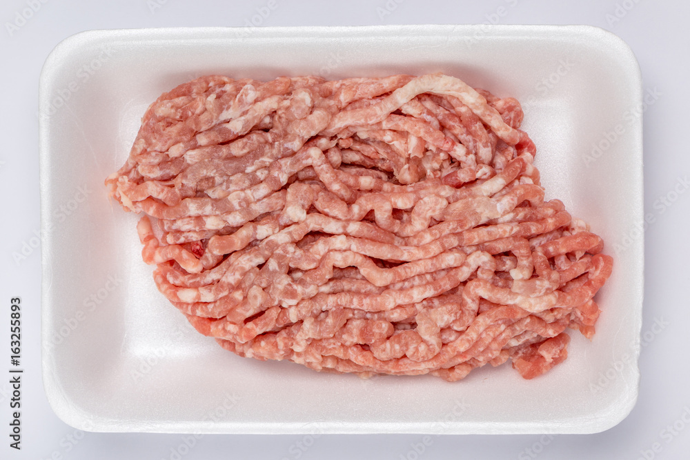A white foam tray of raw minced pork from supermarket, fresh food ingredients concept. A white foam tray of raw minced pork from supermarket, fresh food ingredients concept.