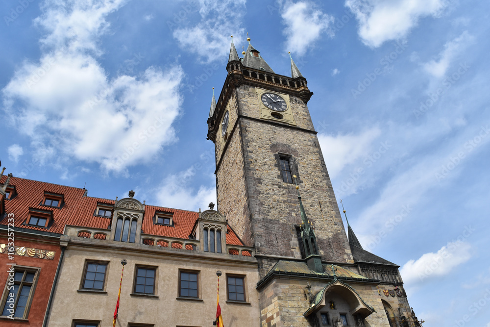 The clock tower of Old Town Hall in Prague in Czech Republic, with blue sky and white clouds in the background.