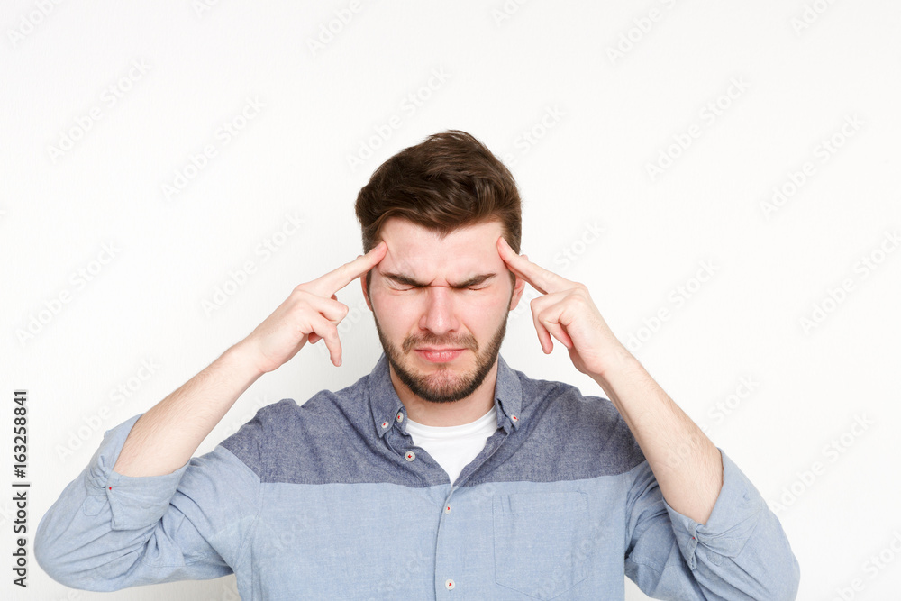 Concentrated pensive man holding fingers on temple Concentrated pensive man holding fingers on temple