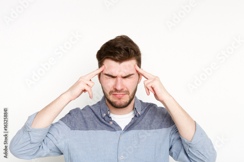 Fotografie Concentrated pensive man holding fingers on temple