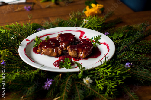 meat with fresh herbs and cherry sauce, ready to eat.