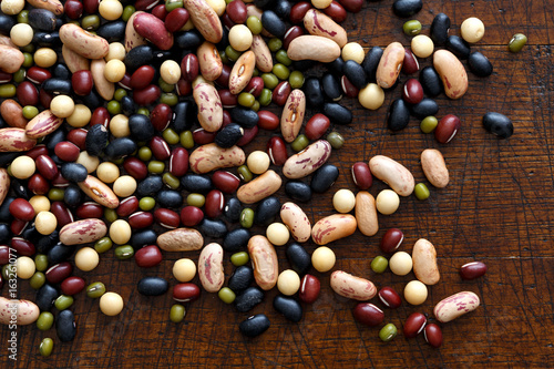 Mixed dry beans on dark wood from above. photo