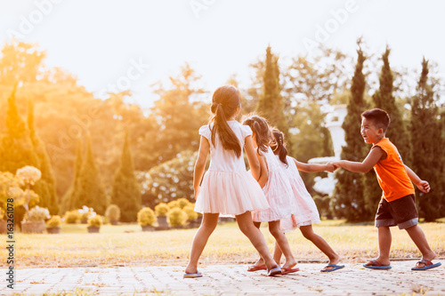 Asian children holding hand and walking together in the park in vintage color tone