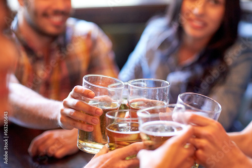 Slika na platnu happy friends drinking beer at bar or pub