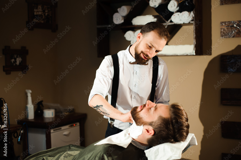 Master cuts hair and beard of men in the barbershop Master cuts hair and beard of men in the barbershop