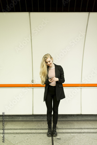 Woman standing on a subway ...