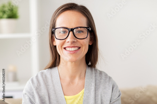 happy smiling middle aged woman in glasses at home