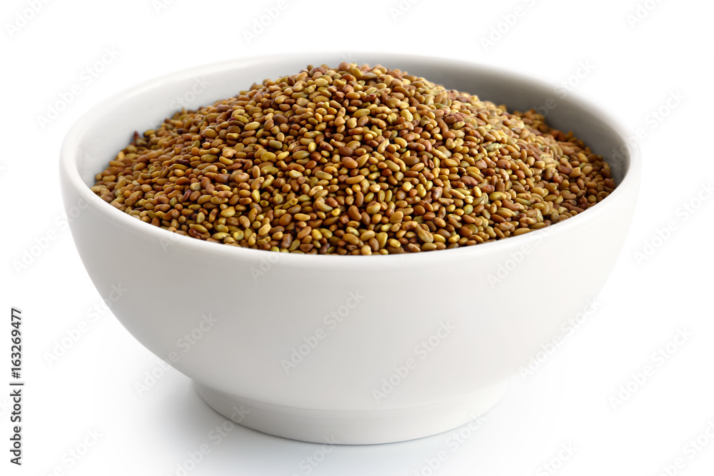 Alfalfa seeds in white ceramic bowl isolated on white. Alfalfa seeds in white ceramic bowl isolated on white.