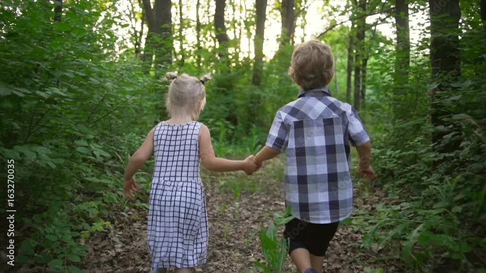 Children couple boy girl holding hands running sunny park tree rapid slow motion Children couple boy girl holding hands running sunny park tree rapid slow motion