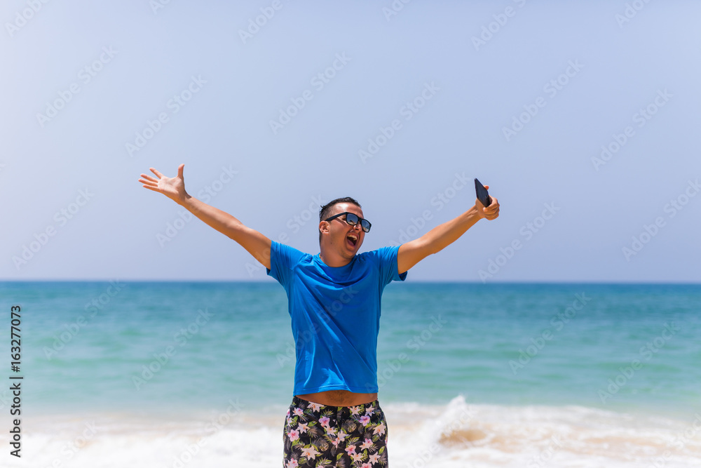 Young man hold cellphone take picture of summer beach panoramic sea view Young man hold cellphone take picture of summer beach panoramic sea view