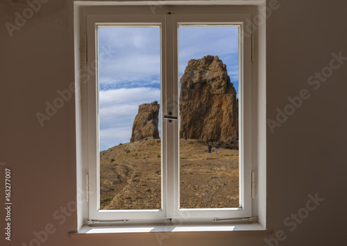 Closed window and a view of a mountain on a sunny day photo