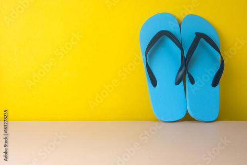 blue sandal on yellow background in summer concept