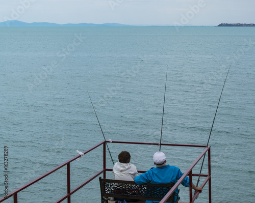 Old couple sitting and fishing together © Kemal