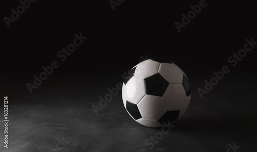 Classic soccer ball on black background. © kulichok