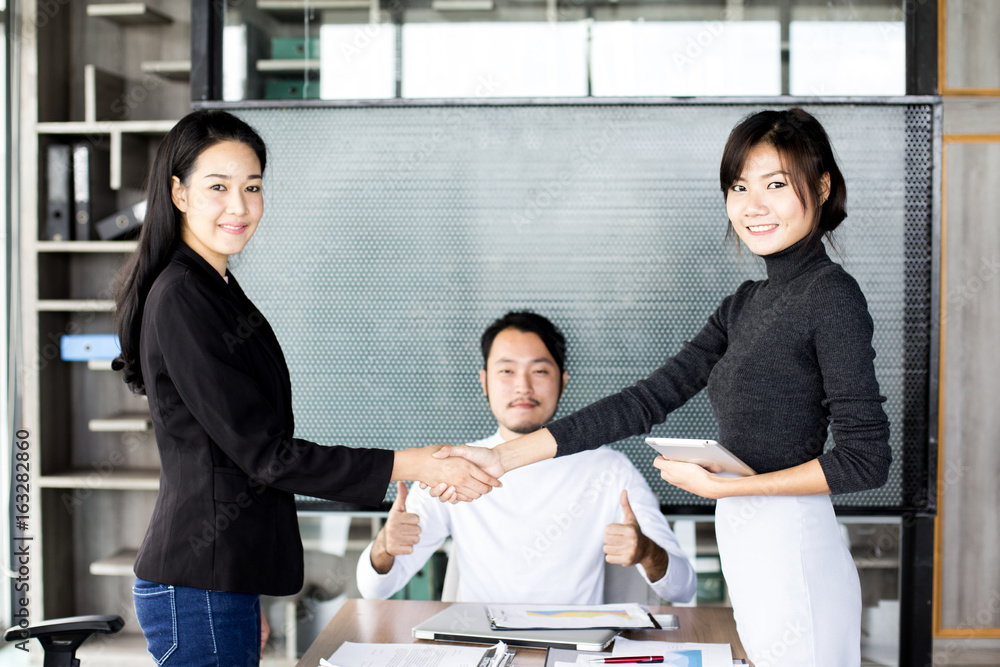 Asian businesspeople shaking hands greeting each other while meeting team, business agreement concept. Asian businesspeople shaking hands greeting each other while meeting team, business agreement concept.