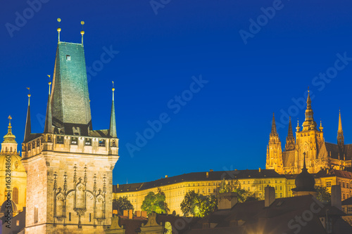 Prague Castle in Mala Strana district and Charles Bridge Tower during blue hour sunset in Czech Republic