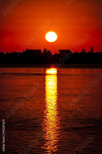 sunset behind island over ocean 