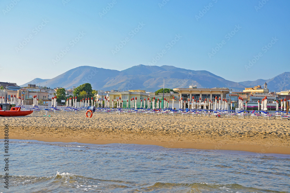 Cozy clean beach of Gaeta with the mountains in the background and the sea Cozy clean beach of Gaeta with the mountains in the background and the sea