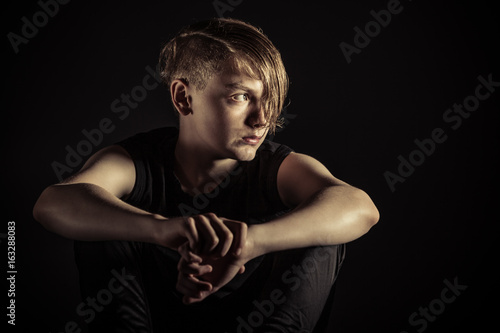 Depressed teen looking sideways over darkness