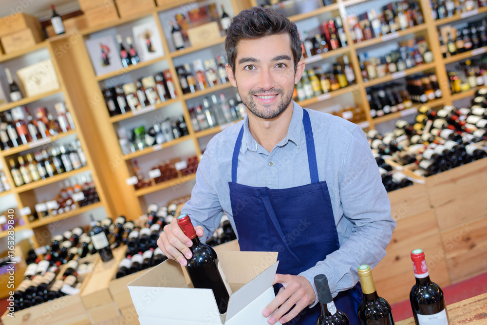 Wine merchant packaging bottles into a box Wine merchant packaging bottles into a box