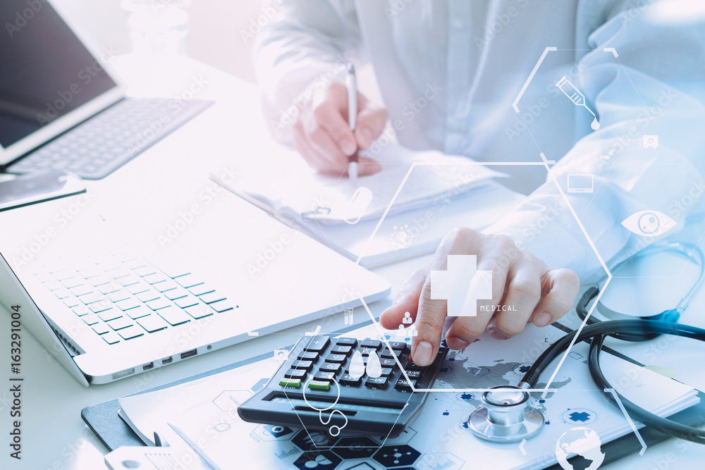 © everythingpossible - Healthcare costs and fees concept.Hand of smart doctor used a calculator for medical costs in modern hospital