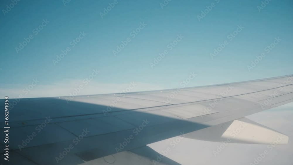 View from the window in the plane to sky and clouds. Traveling by air concept. Close-up view of wing of an airplane. View from the window in the plane to sky and clouds. Traveling by air concept. Close-up view of wing of an airplane.