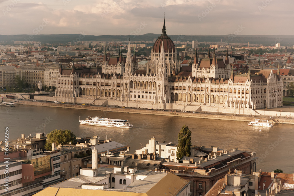 Fototapeta premium Travel and european tourism concept. Parliament and riverside in Budapest Hungary with sightseeing ships during summer day. Toned image