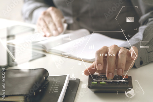 businessman hand working with finances about cost and calculator and latop with mobile phone on withe desk in modern office