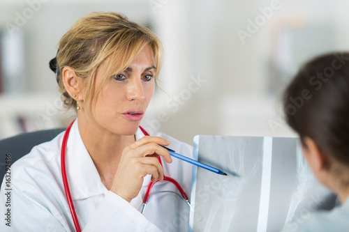 Middle aged doctor talking to patient