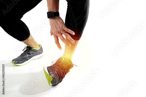 Runner sportsman holding ankle in pain with Broken twisted joint running sport injury and Athletic man touching foot due to sprain on white background photo
