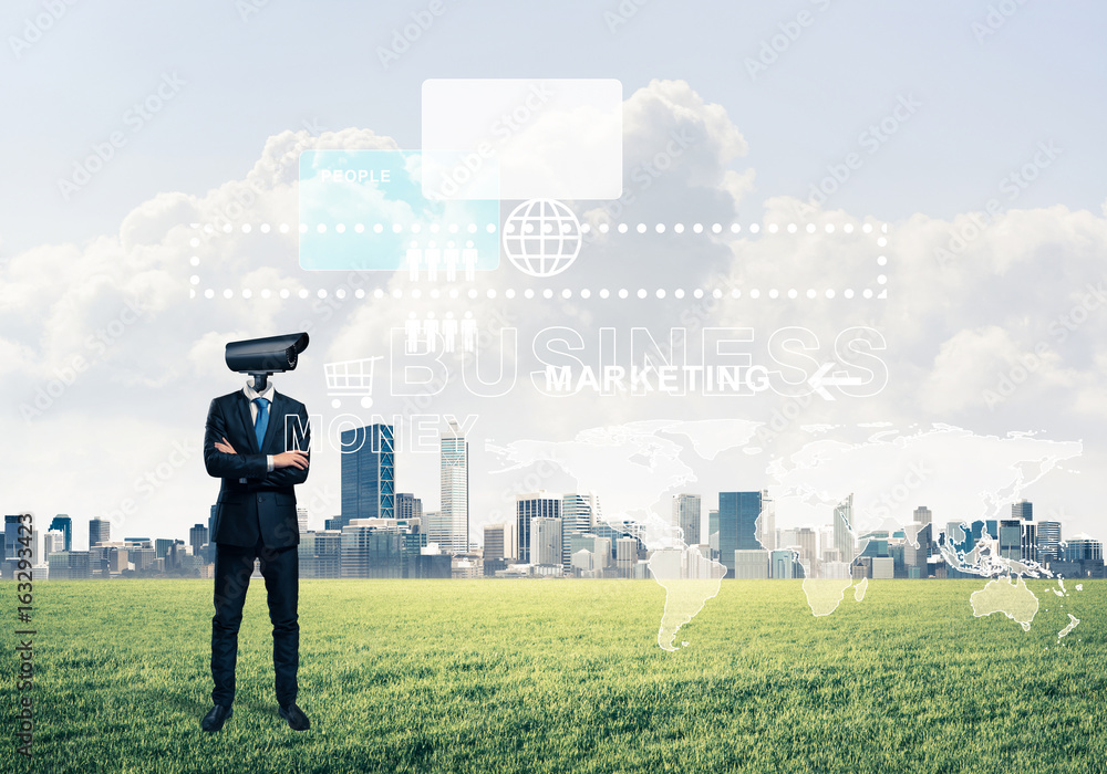 Camera headed man standing on green grass against modern citysca Camera headed man standing on green grass against modern citysca