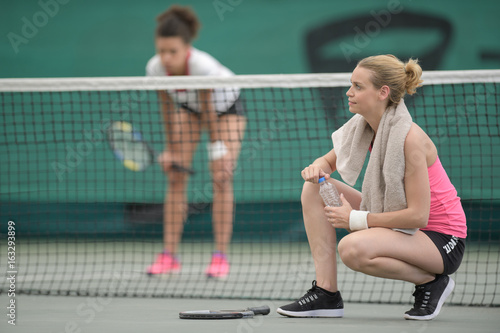 Women taking a break on tennis court