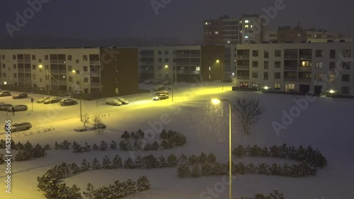 snowstorm between courtyards with pine covered snow in dark. 4K photo