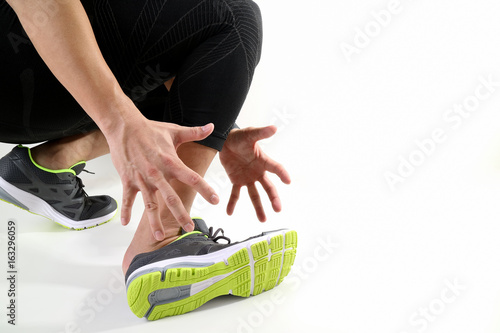 Runner sportsman holding ankle in pain with Broken twisted joint running sport injury and Athletic man touching foot due to sprain on white background