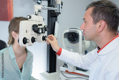 Optometrist adjusting equipment during consultation