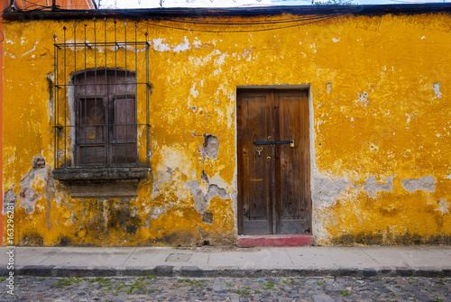 Window and wooden door in colonial house of La Antigua Guatemala, Central America.