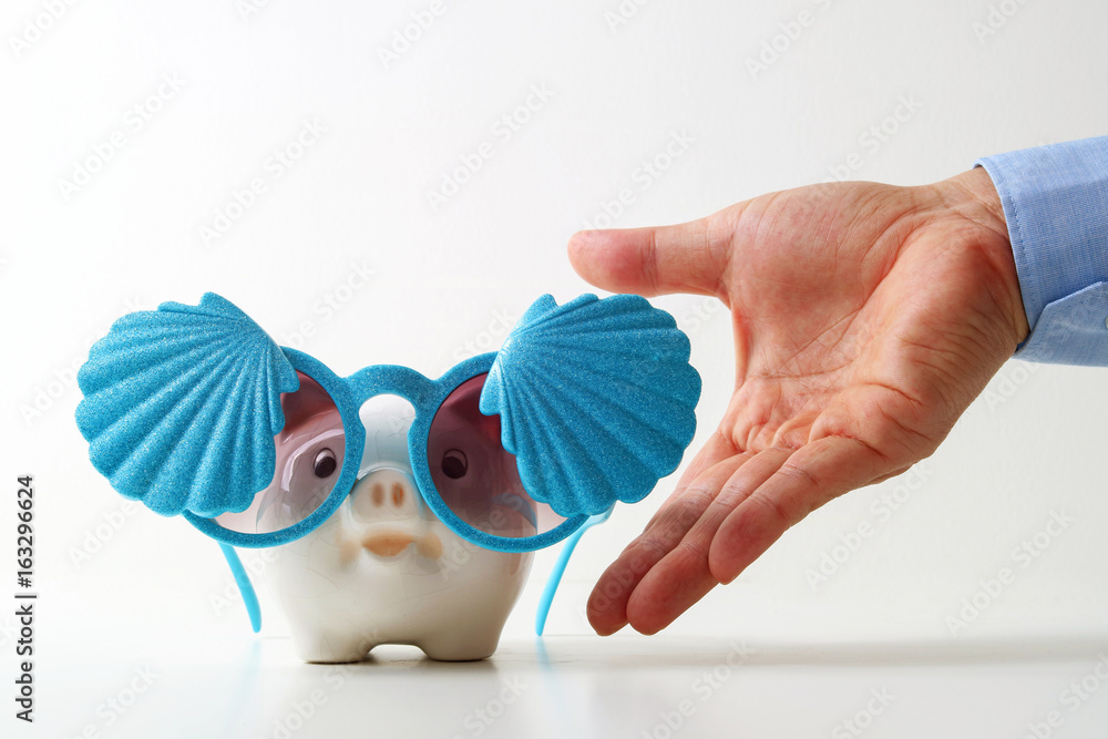 Fototapeta premium Travel insurance concept.business insurance agent hand in gesture of protection of piggy bank with shell sunglasses on white background