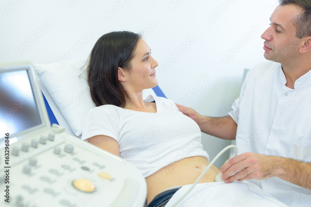Doctor reassuring patient while performing ultrasound Doctor reassuring patient while performing ultrasound