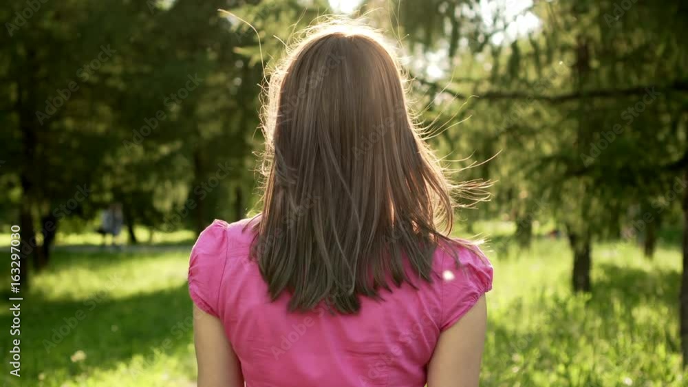 Slow Motion Pov Woman walking in park, relaxing summer vacation, turn and smile. Camera following behind Slow Motion Pov Woman walking in park, relaxing summer vacation, turn and smile. Camera following behind