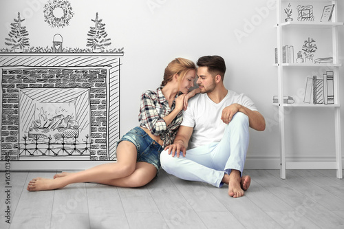 Happy young couple sitting ...