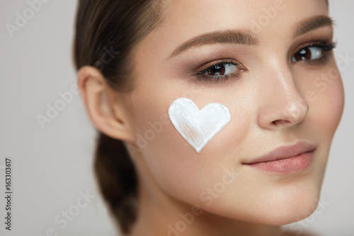 Beauty Skin Care. Woman With Heart Of Cream On Face