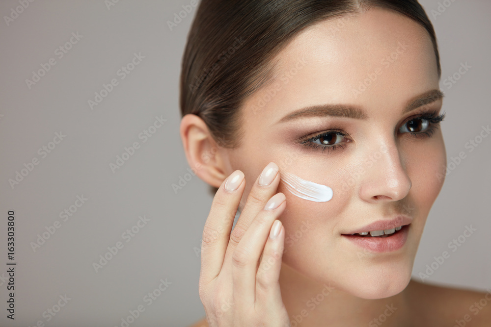 Beauty Skin Care. Young Woman With Natural Makeup Applying Cream